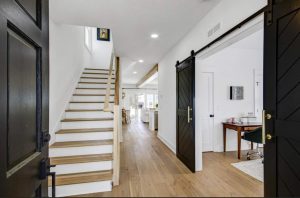 A modern home sports an inviting and sophisticated entryway in stark white and black hues.